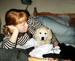 Dog Carer Au Pairs Golden Retriever puppy on the bed with Anna